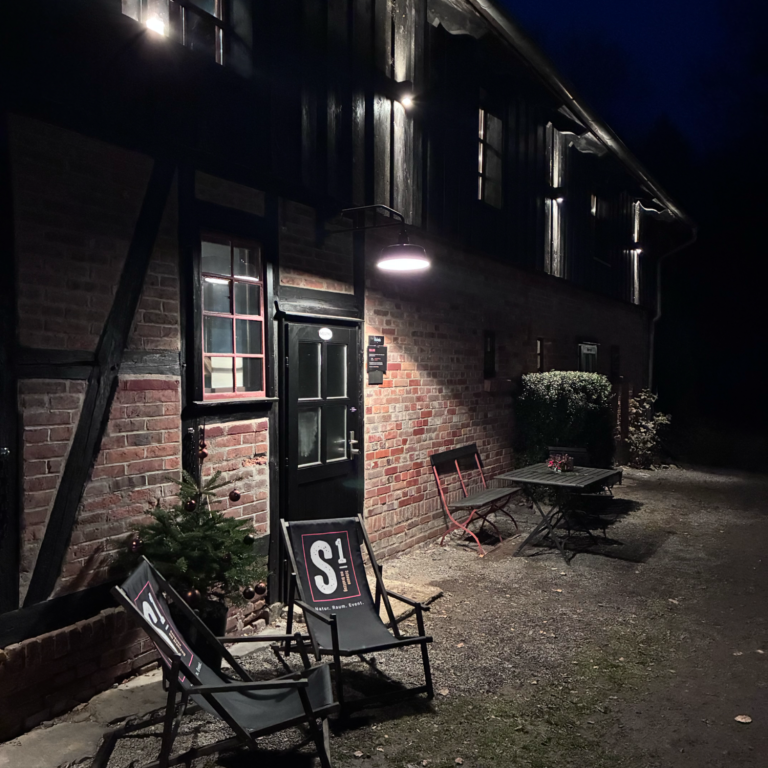 Gemütlicher Raum mit Holzbalken, Tischen und Stühlen für Besprechungen.